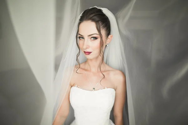 Luxus menyasszony fehér ruhában pózol, miközben készül az esküvői szertartás — Stock Fotó
