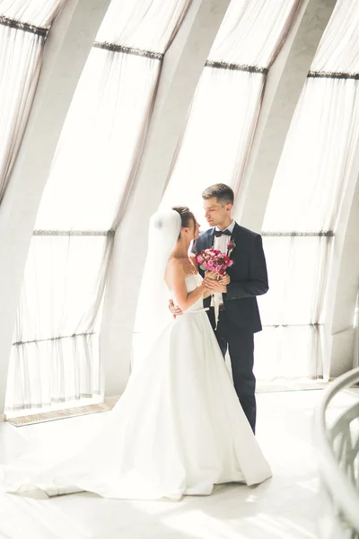 Gyönyörű pár, a menyasszony és a vőlegény pózol a régi város backgrounf erkéllyel — Stock Fotó