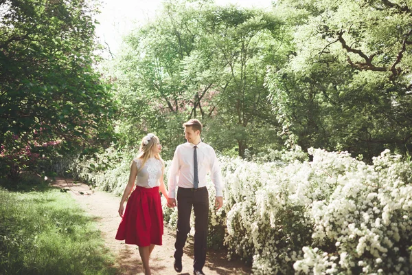 Stilvolle schöne glückliche Hochzeitspaar küsst und umarmt im botanischen Garten — Stockfoto