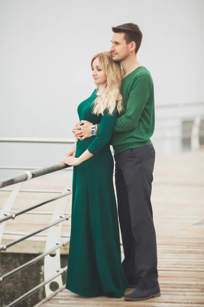 Preciosa pareja besándose y abrazándose en un muelle de mar — Foto de Stock