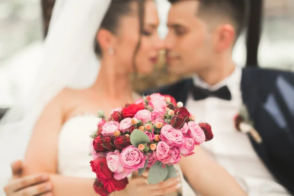 Retrato de feliz pareja de recién casados con ramo de flores — Foto de Stock