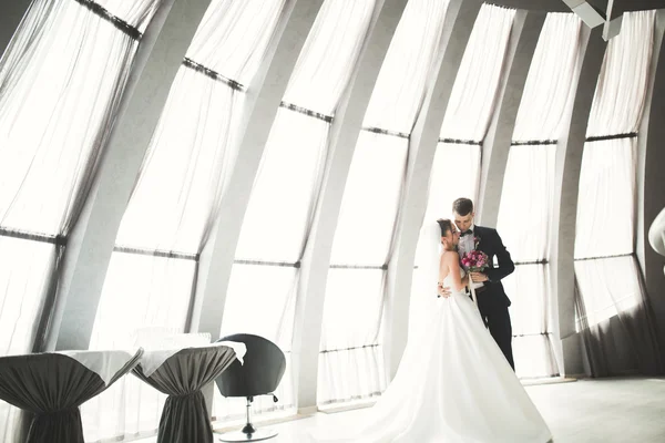 Lovely happy wedding couple, bride with long white dress posing in beautiful city — Stock Photo, Image