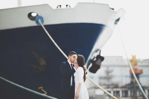 Feliz novia y novio abrazándose cerca de la nave — Foto de Stock