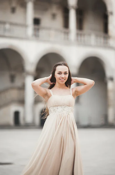 Bella ragazza, modello con i capelli lunghi in posa nel vecchio castello vicino colonne. Vavello di Cracovia — Foto Stock