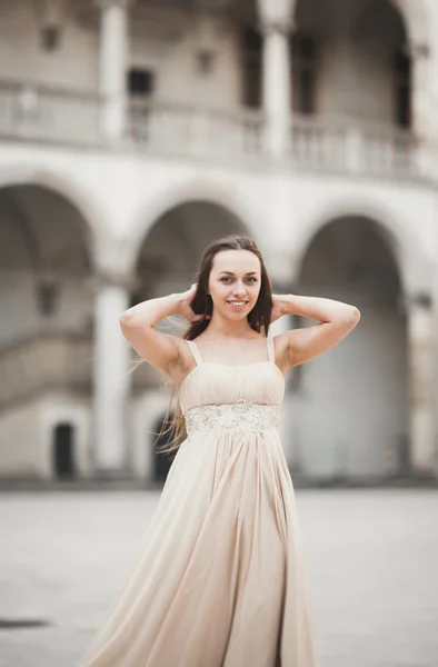 Schönes Mädchen, Model mit langen Haaren, das in einem alten Schloss in der Nähe von Säulen posiert. Krakauer Bauchnabel — Stockfoto