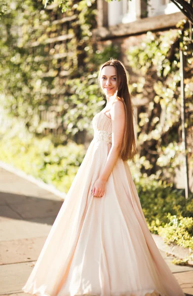 Atractiva joven con vestido largo disfrutando de su tiempo al aire libre en el fondo del atardecer del parque —  Fotos de Stock