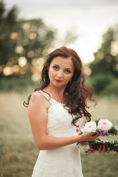 花嫁。花の花輪、暖かい夏の日に花束と一緒に公園で若い金髪美人 — ストック写真
