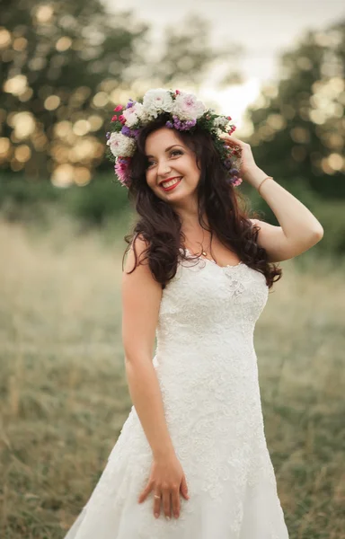Braut. schöne junge blonde Frau im Park mit Blumenkranz und Blumenstrauß an einem warmen Sommertag — Stockfoto