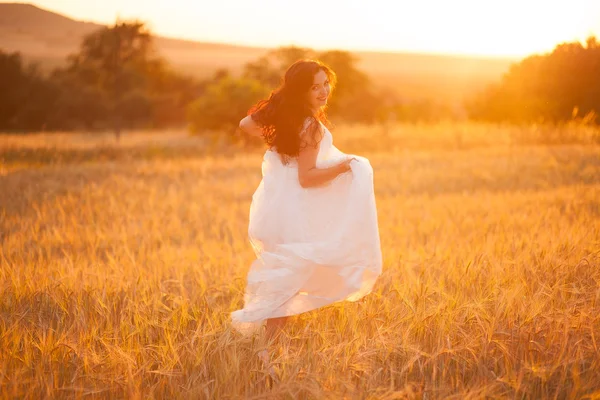 Szczęśliwa piękna młoda panna młoda na zewnątrz na letniej łące o zachodzie słońca — Zdjęcie stockowe