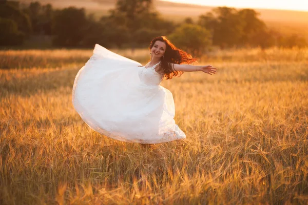 Feliz joven novia hermosa fuera en un prado de verano al atardecer —  Fotos de Stock