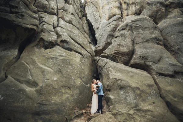 Casal feliz beijando e abraçando perto de um penhasco alto — Fotografia de Stock