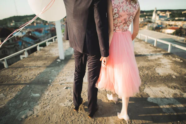 Retrato al aire libre bastante soleado de pareja joven y elegante mientras se besa en el techo con vista a la ciudad — Foto de Stock