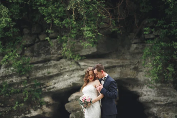 Allegro matrimonio coppia posa nea rocce — Foto Stock