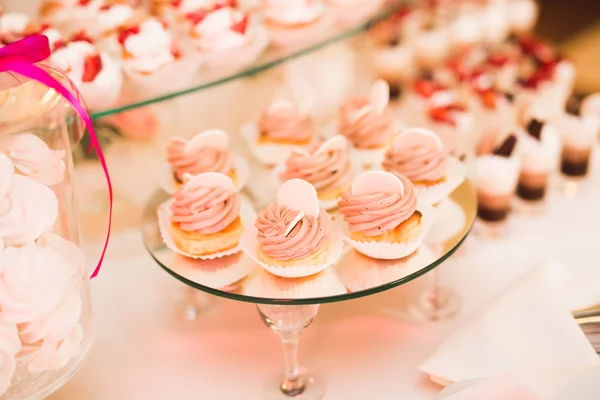 Deliciosa e saborosa mesa de sobremesa com cupcakes tiros na recepção closeup — Fotografia de Stock