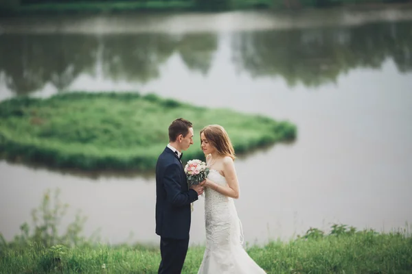 Pareja romántica de la boda, hombre y mujer, posando cerca del hermoso lago —  Fotos de Stock