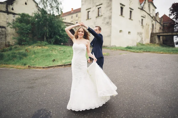 Beau couple de mariage romantique de jeunes mariés étreignant près du vieux château — Photo