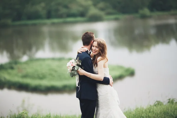 Romantico matrimonio coppia, uomo e moglie, in posa vicino al bellissimo lago — Foto Stock