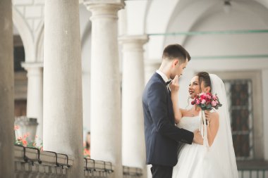 Güzel, mutlu bir düğün çifti, güzel şehirde uzun beyaz elbiseli bir gelin.