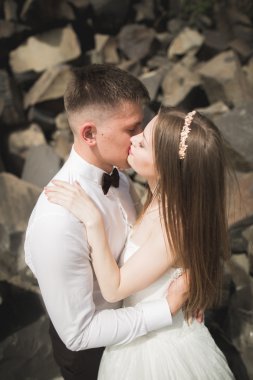 Evlilik çift büyük taşlar üzerinde poz. Gelin ve damat