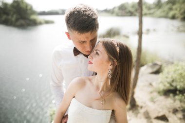 Öpüşen düğün çifti güzel manzarada kalıyor.