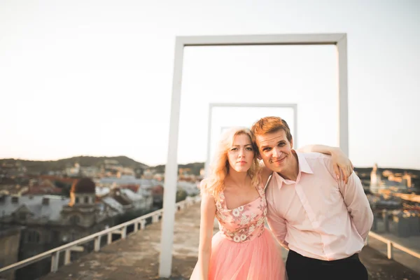 阳光很室外肖像的年轻时尚夫妇与城市景观屋顶上接吻时 — 图库照片