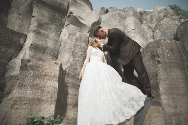 Casamento casal posando em grandes pedras. A noiva e o noivo — Fotografia de Stock