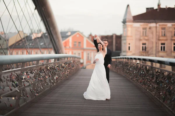 华丽的新婚夫妇，新娘和新郎在克拉科夫桥上摆姿势 — 图库照片