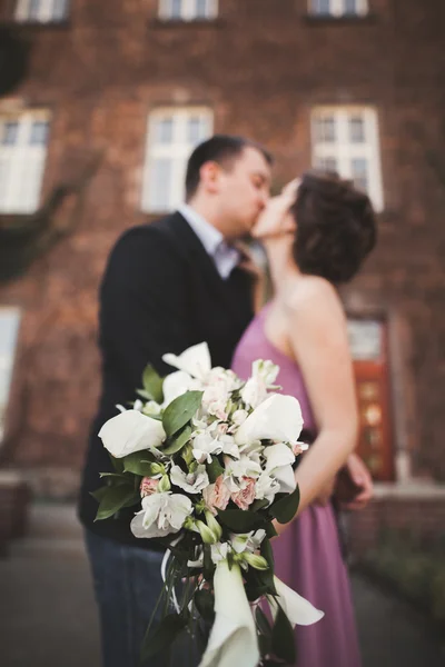背景に新婚カップルと結婚式の花花束 — ストック写真