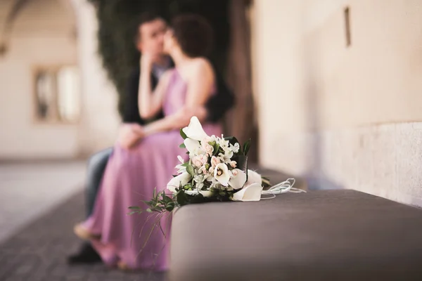 Svatební květiny kytice s novomanželé pár na pozadí — Stock fotografie
