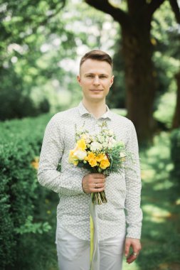 Adam, mükemmel bir düğün buket ile poz damat