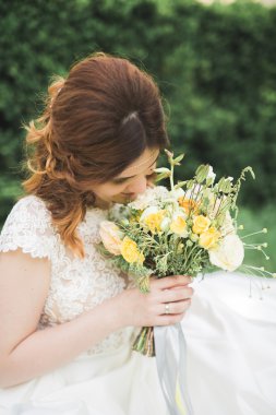 Gelin. Güzel sarışın kadın çiçek çelenk ve buket sıcak yaz gününde park