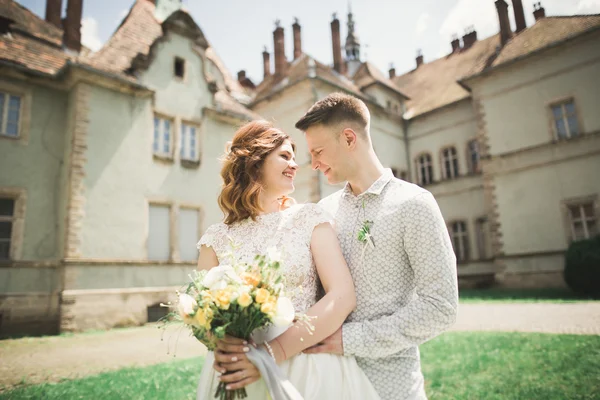 Schönes romantisches Brautpaar, das sich in der Nähe des alten Schlosses umarmt — Stockfoto