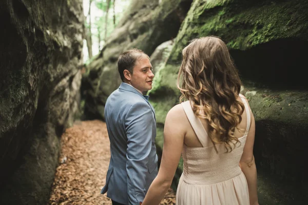 Splendido matrimonio coppia baci e abbracci nella foresta con grandi rocce — Foto Stock