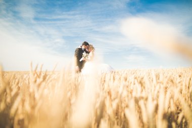 Duygusal güzel gelin, yeni evli damada yakın planda sarılıyor.