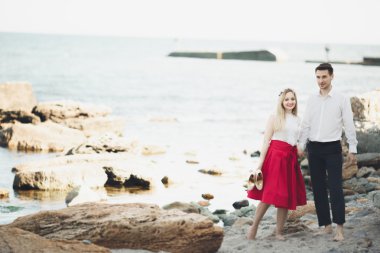 Deniz, mavi gökyüzü yakınındaki taş poz romantik sevgi dolu Çift