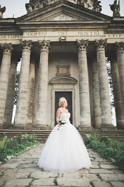Hermosa novia rubia elegante posando cerca del viejo castillo —  Fotos de Stock