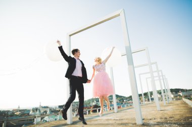 Sevgi dolu çift atlama ve eski şehir'in backgrounf ile çatı üzerinde gülümseyen