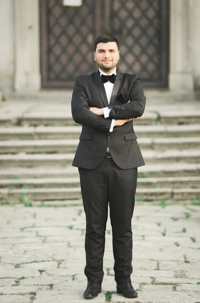 Elegante noivo posando no fundo velho castelo — Fotografia de Stock