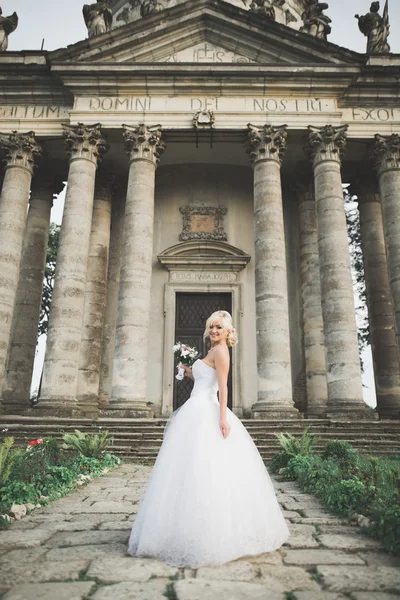 Bella sposa bionda elegante posa vicino al vecchio castello — Foto Stock