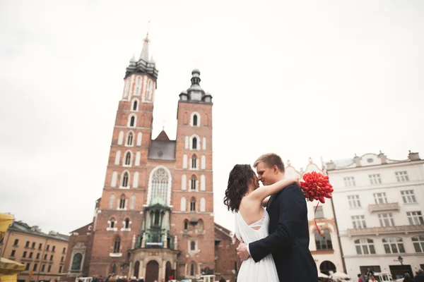 Elegante schöne Hochzeitspaar zu Fuß auf dem Hauptplatz in Krakau — Stockfoto