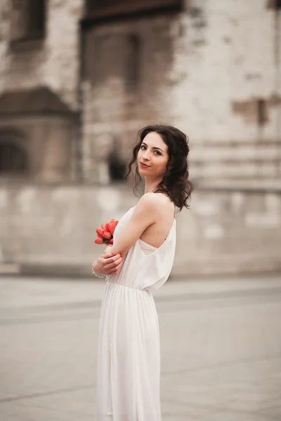 Hermosa novia joven con ramo de novia en la iglesia de fondo — Foto de Stock