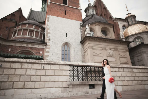 Hochzeitspaar, Brautpaar beim Spaziergang in der Nähe einer Kirche in Krakau — Stockfoto