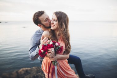 Mavi Denizi çevresinde büyük bir taş üzerinde oturan Düğün çifti