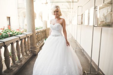 Lüks bir gelin, bir kız buketle poz veriyor ve gülümsüyor.