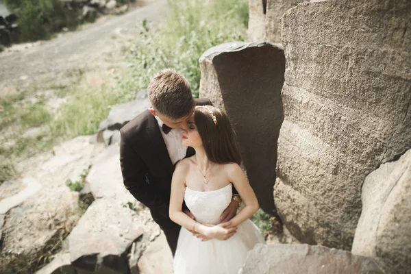 Svatební pár pózuje na velké kameny. Nevěsta a ženich — Stock fotografie
