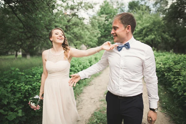 Hermosa pareja de boda en el parque. besarse y abrazarse — Foto de Stock