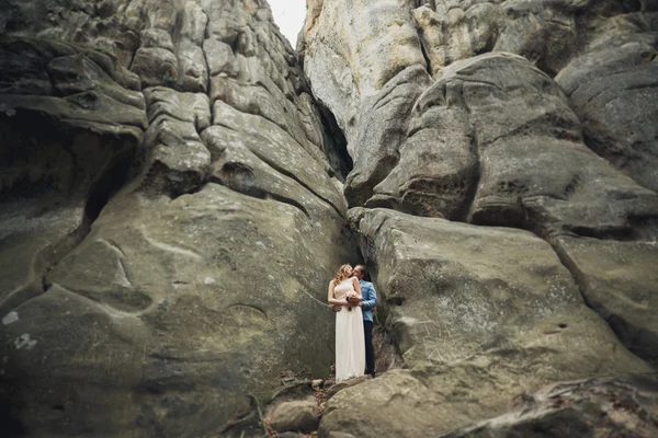 Happy wedding couple kissing and hugging near a high cliff — Stock Photo, Image