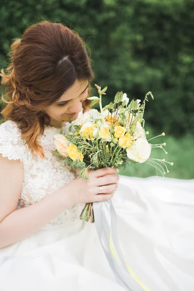 Hermosa novia joven de lujo en vestido de novia posando en el parque — Foto de Stock