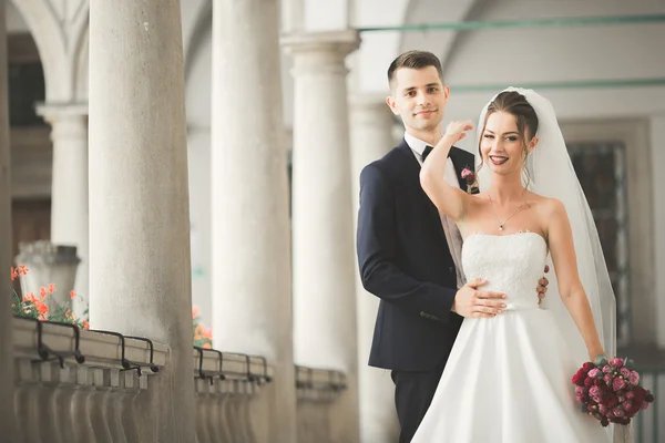 Mooi gelukkig bruidspaar, bruid met lange witte jurk poseren in mooie stad — Stockfoto