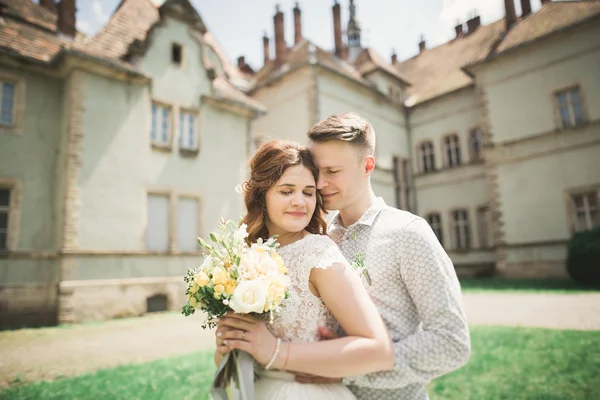 刚刚结婚的姿势和亲吻与背景上古老的城堡 — 图库照片